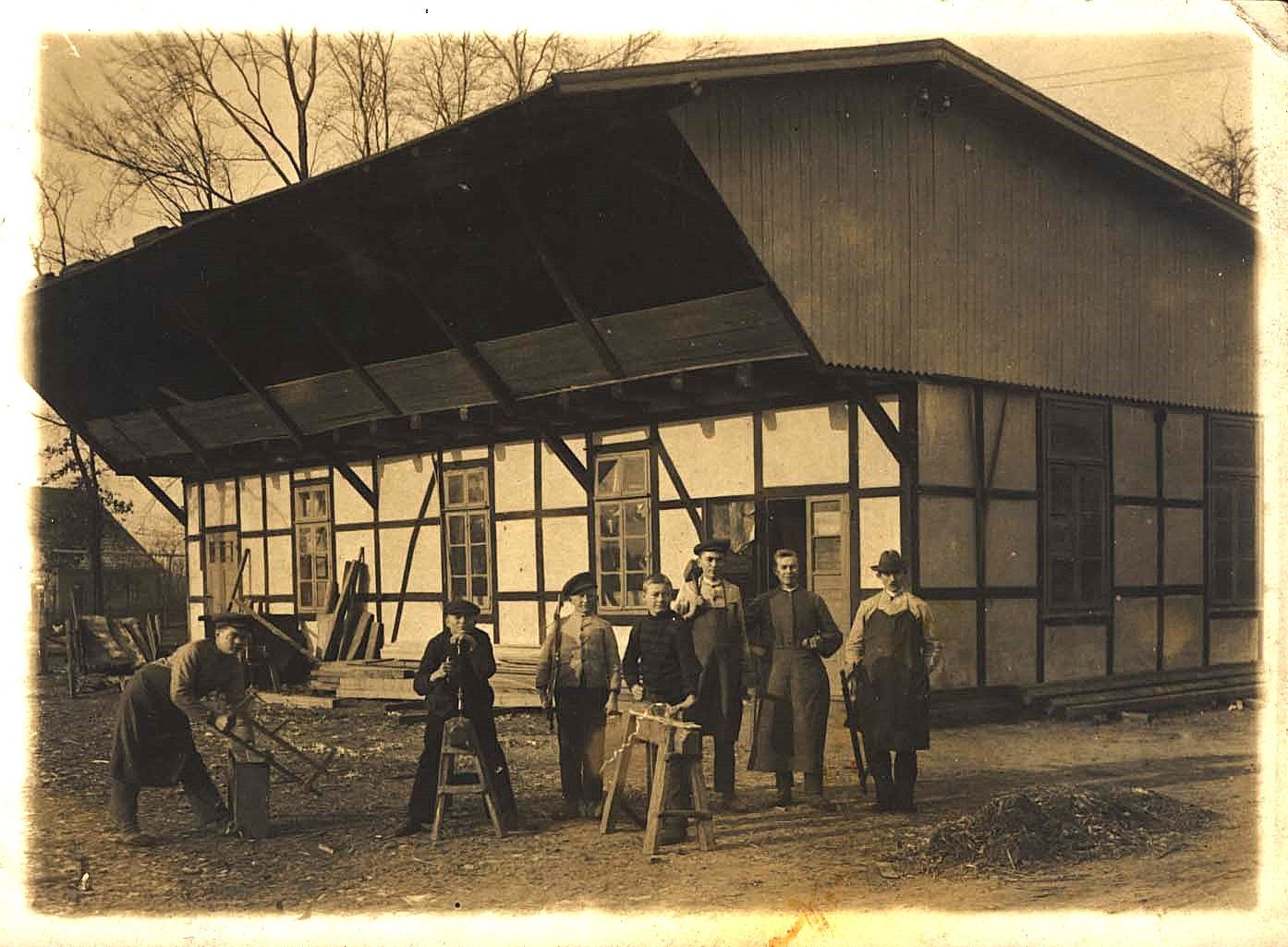 Tischlerei Heinrich Lübbert in Löhne/Falschheide im Jahre 1912. ganz links zeigt der Lehrling Wilhelm Stuke, mit Tischlerschürze, den Umgang mit einer Spannsäge
